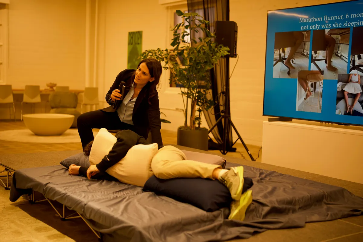 Dr. Ariana coaching a volunteer through proper sleep position during the PainProof workshop.