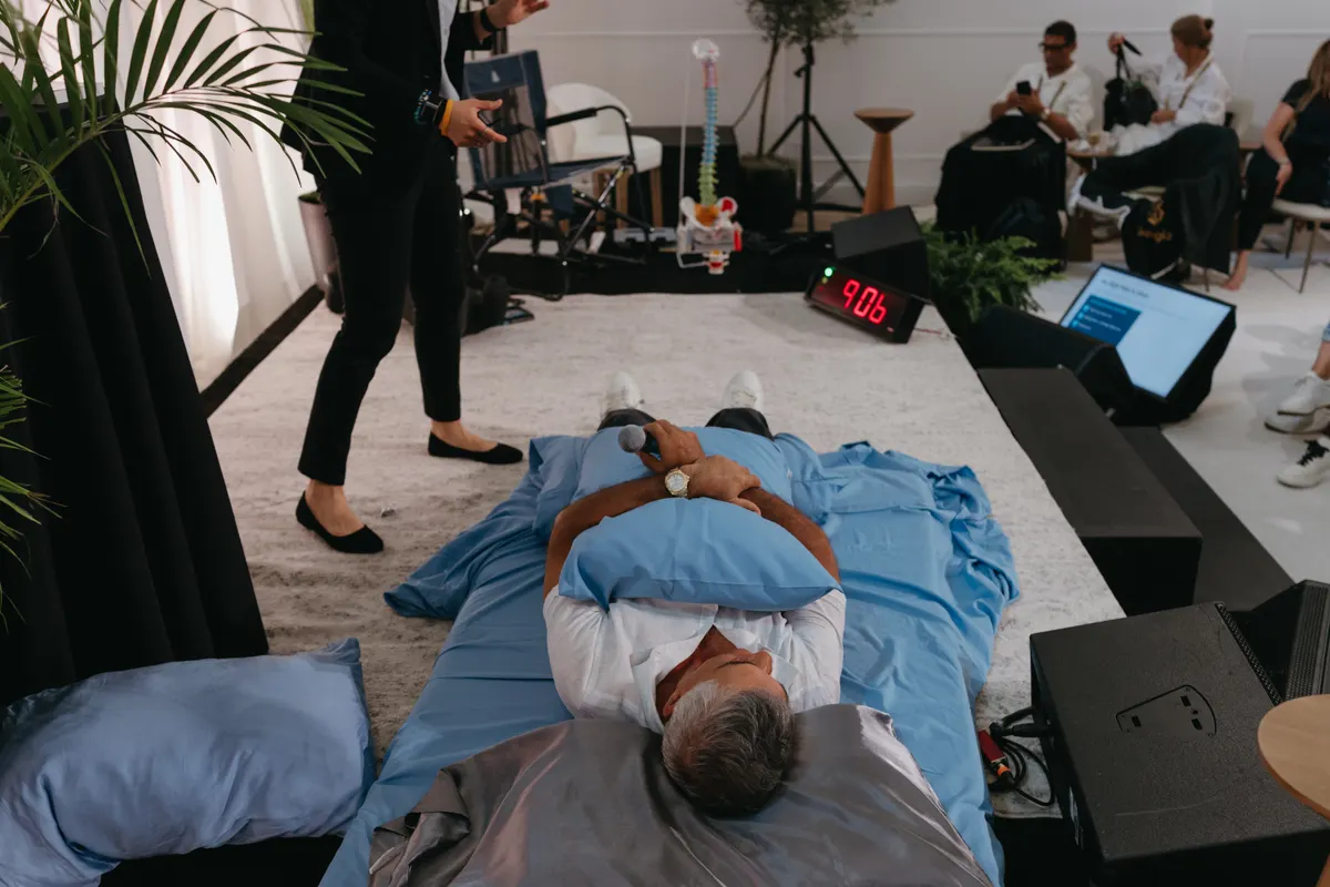 A senior executive runs the live sleep protocol on stage — Human OS installed in real time.
