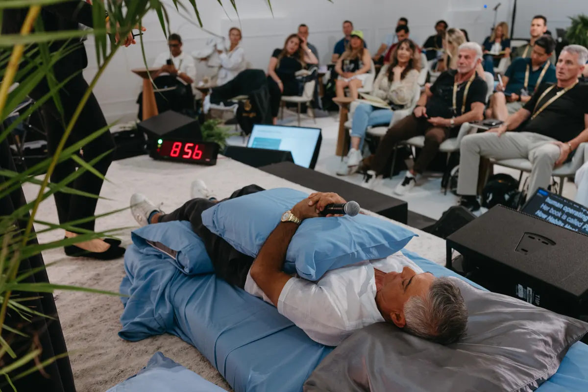 Corporate workshop in progress — executive on the sleep-protocol demo bed with the full audience watching.